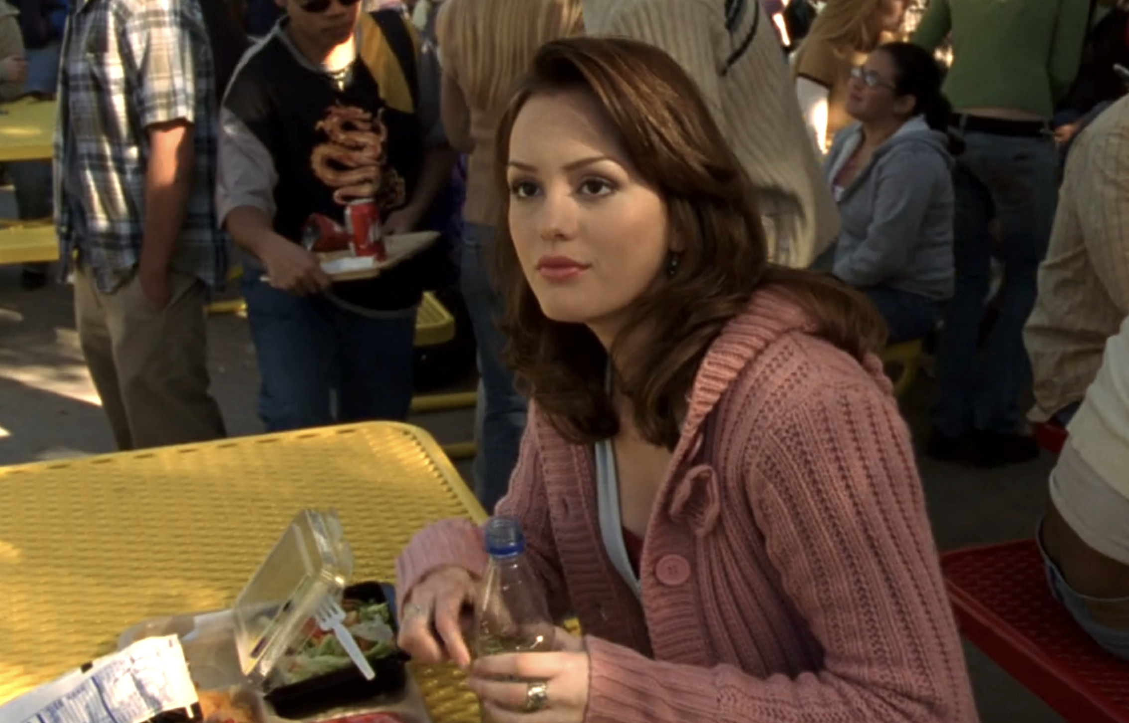 Screenshot from S1E14 of Veronica Mars. Leighton Meester is sitting at a yellow table during lunch a Neptune High. She is looking at an off-screen Veronica with some glibness.