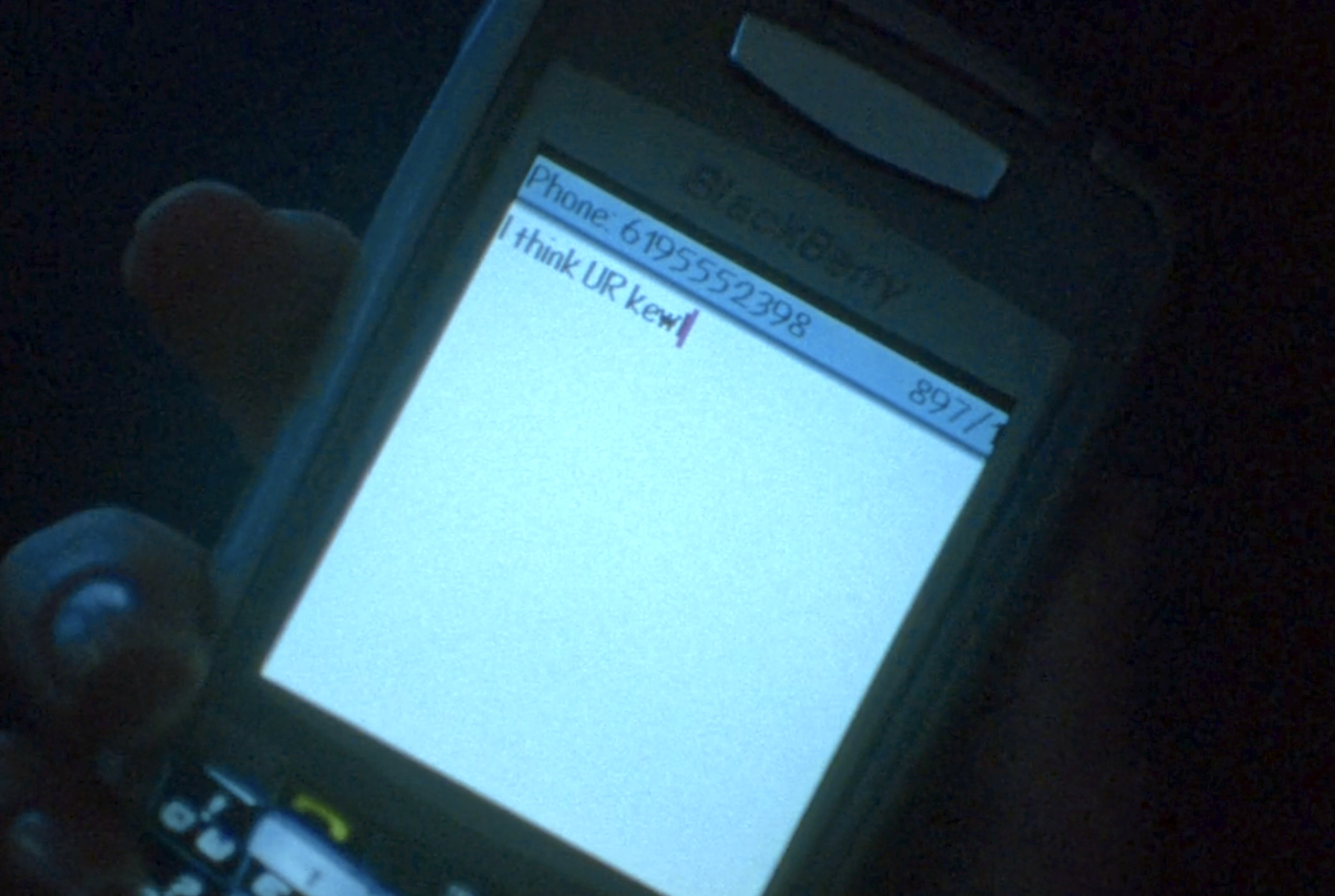 Screenshot from Veronica Mars S1E15. A Blackberry screen with a text mesage that reads "I think UR kewl."