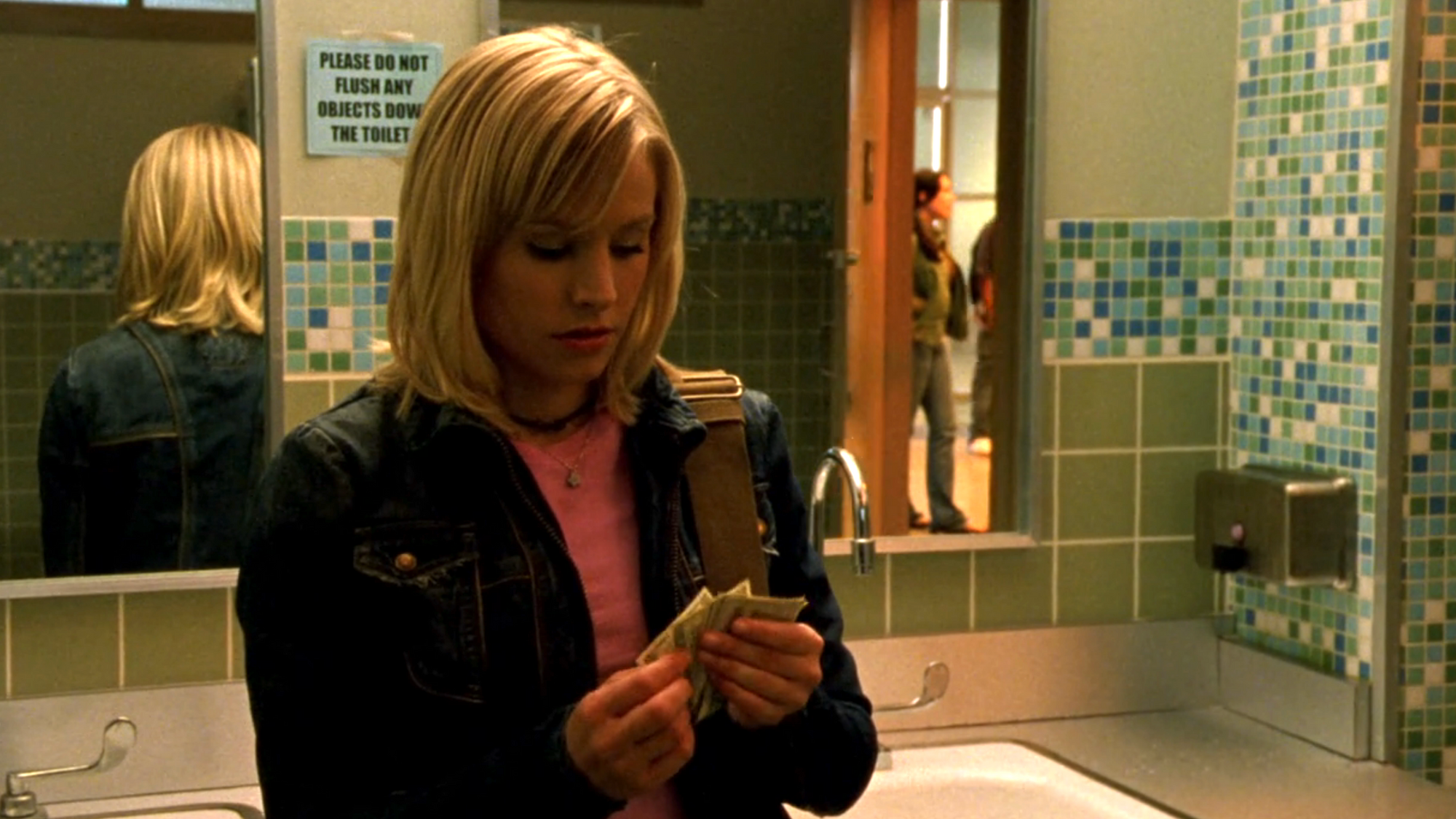 Screenshot from S1E17 of Veronica Mars. Veronica is in the bathroom at Neptune High looking down at cash in her hand and counting it