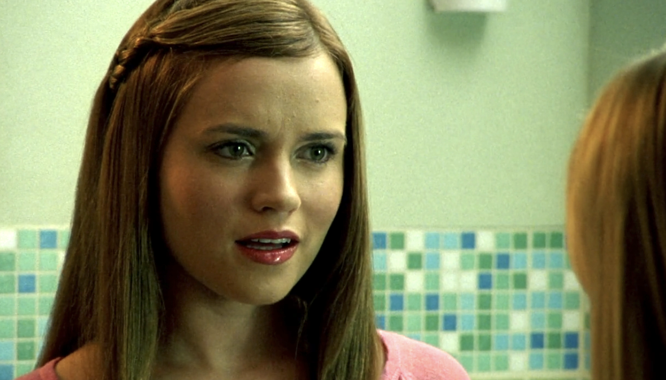 Screenshot from S1E21 of Veronica Mars. Madison Sinclair is standing in the Neptune High bathroom talking to Veronica.