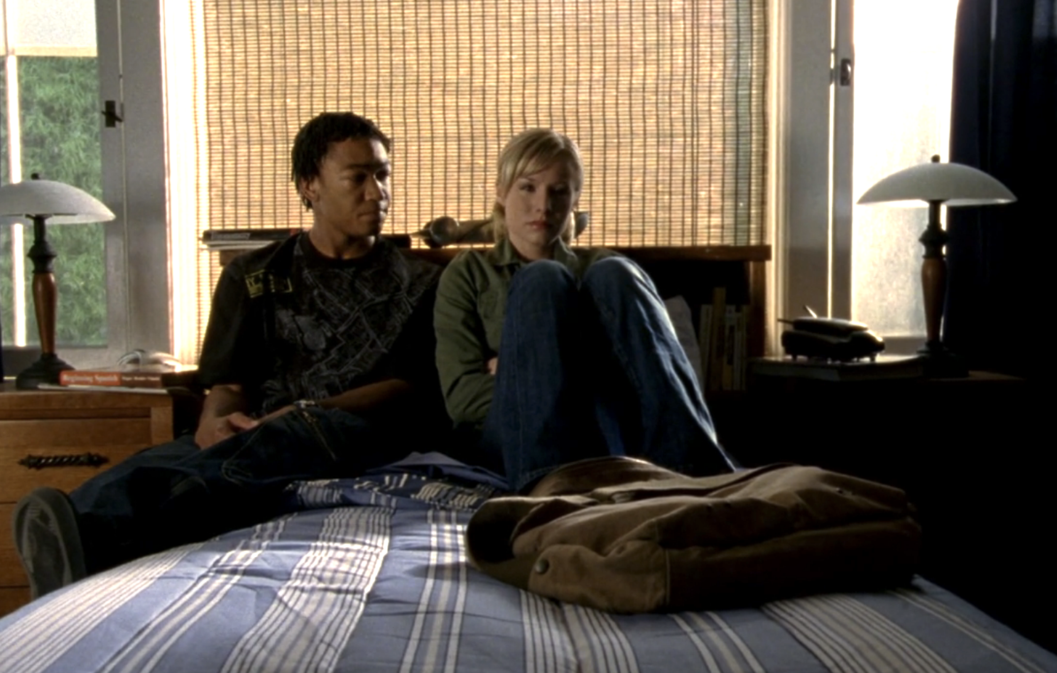 Screenshot from Veronica Mars S1E21. Wallace and Veronica are sitting on Wallace's bed sharing what looks like a sad moment.